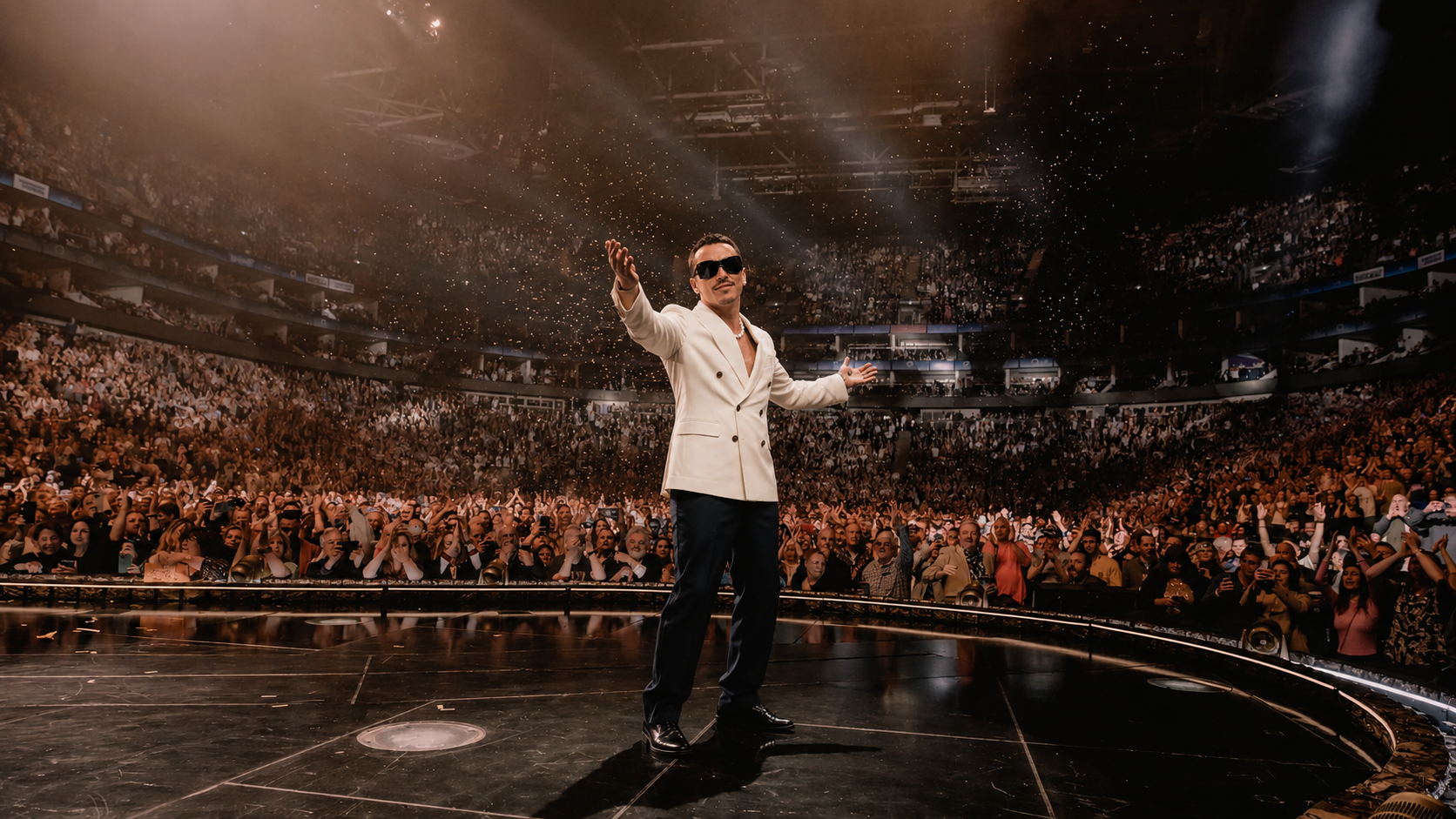 Don Papi greeting the crowd in a white suit at an arena show